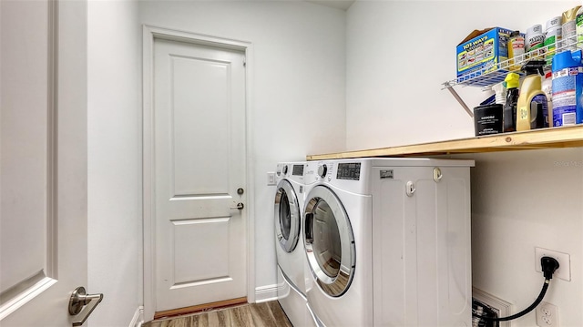 laundry area with washing machine and dryer and hardwood / wood-style floors