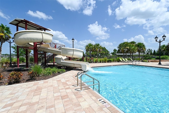 view of swimming pool with a patio and a water slide