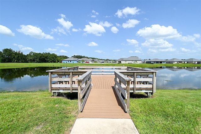 view of dock with a yard and a water view