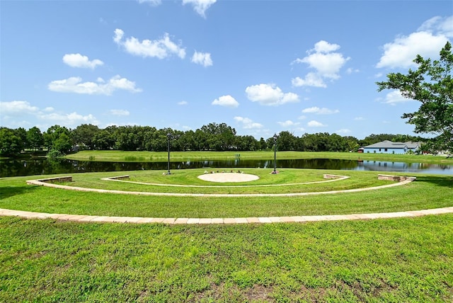 surrounding community featuring a water view and a lawn