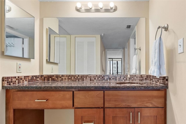 bathroom featuring vanity and backsplash