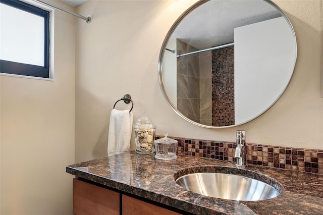 bathroom with vanity and a tile shower