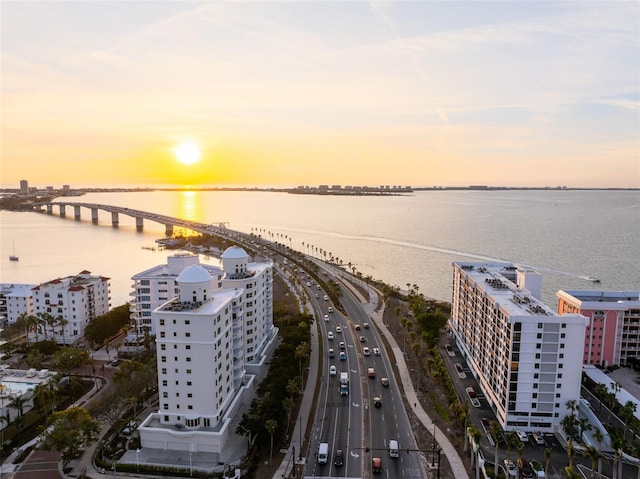 aerial view at dusk featuring a water view