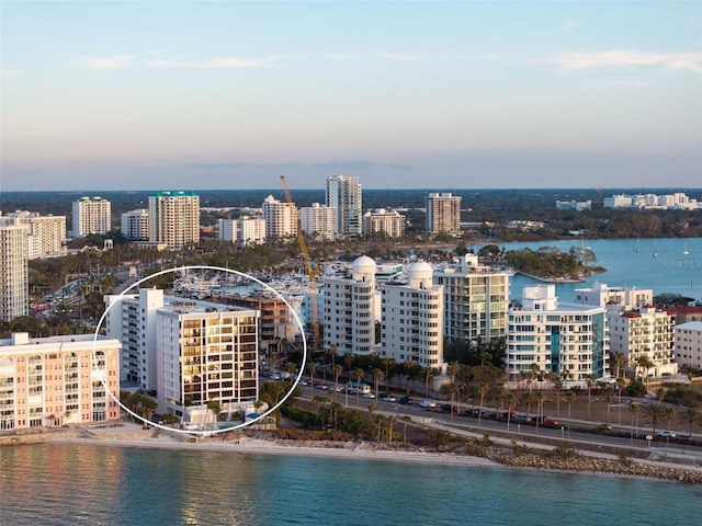 aerial view at dusk featuring a water view