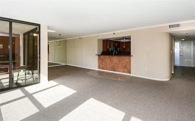 11 Sunset Dr Unit 406, Sarasota, FL 34236 - unfurnished living room featuring visible vents, baseboards, carpet, and ornamental molding