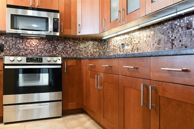 11 Sunset Dr Unit 406, Sarasota, FL 34236 - kitchen with backsplash, brown cabinetry, and appliances with stainless steel finishes