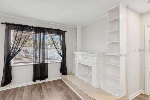 unfurnished living room with built in shelves and wood-type flooring