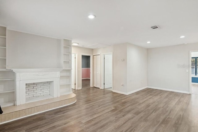 unfurnished living room with hardwood / wood-style flooring and built in features