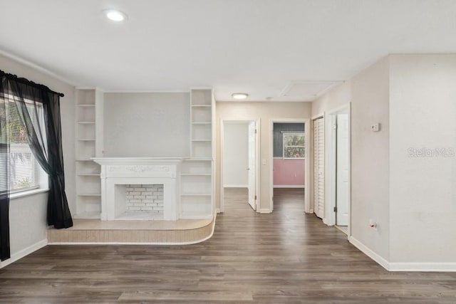 unfurnished living room with built in shelves and dark hardwood / wood-style flooring