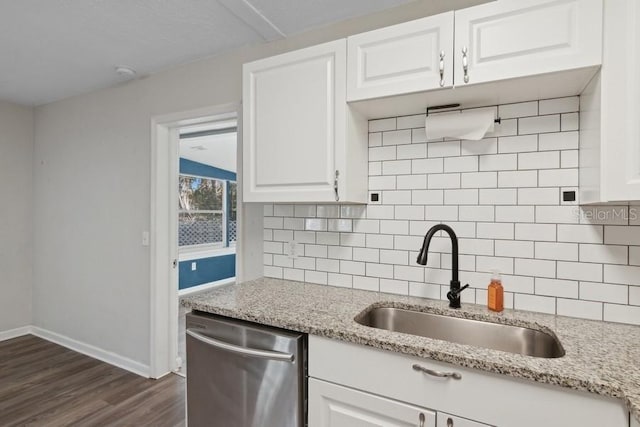 kitchen with white cabinetry, sink, stainless steel dishwasher, and light stone countertops