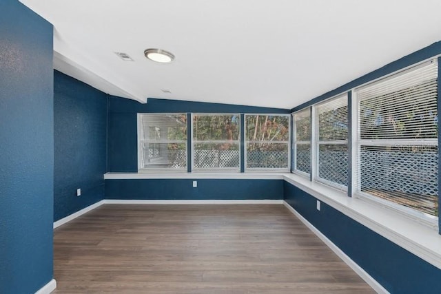 unfurnished sunroom featuring lofted ceiling