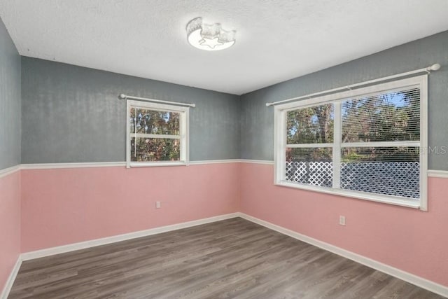 spare room with hardwood / wood-style flooring and a textured ceiling