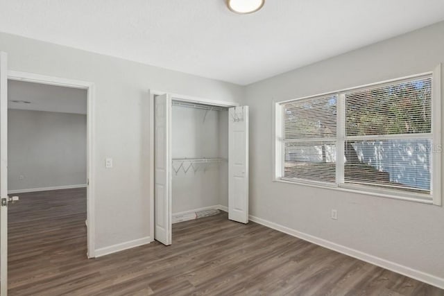 unfurnished bedroom featuring dark hardwood / wood-style flooring and a closet