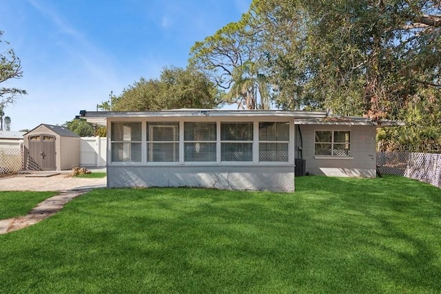 rear view of property with a yard and a sunroom