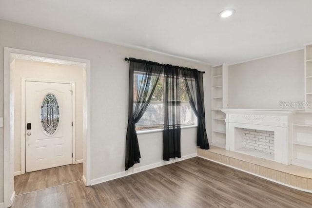 entryway with a tiled fireplace and hardwood / wood-style flooring