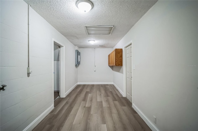 corridor featuring light hardwood / wood-style flooring and a textured ceiling