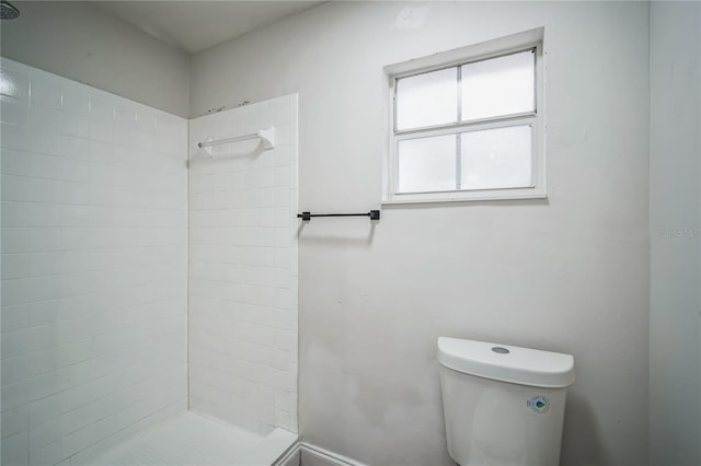 bathroom with tiled shower and toilet