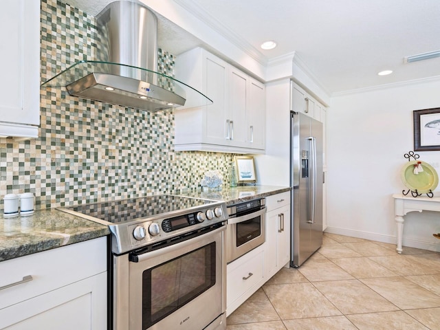 kitchen with dark stone countertops, appliances with stainless steel finishes, extractor fan, and white cabinets