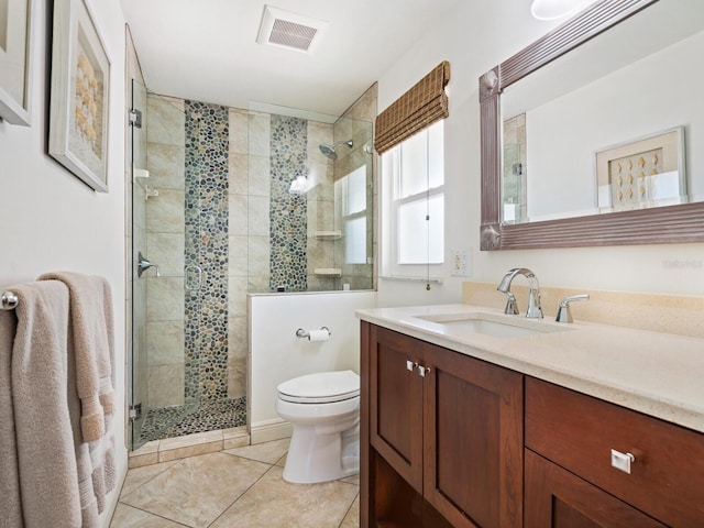 bathroom with tile patterned floors, vanity, toilet, and a shower with door