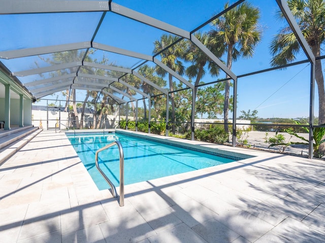 view of swimming pool featuring a patio and glass enclosure