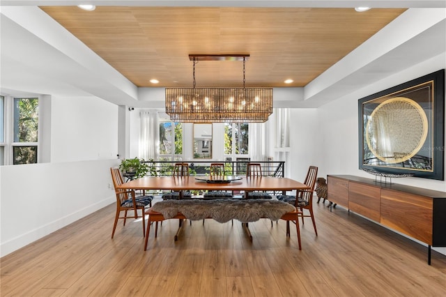 dining space featuring an inviting chandelier, light hardwood / wood-style flooring, and wooden ceiling