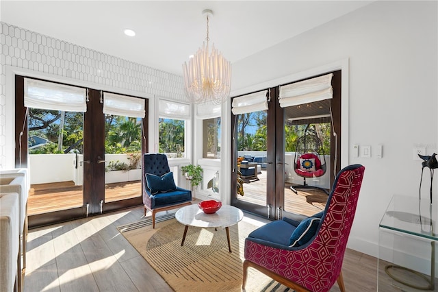 sitting room with hardwood / wood-style floors, an inviting chandelier, and french doors