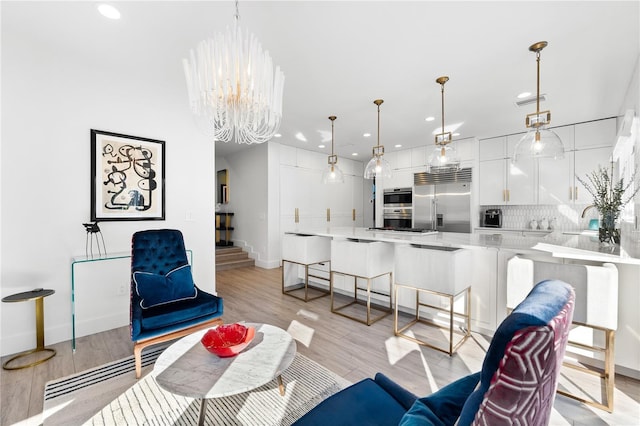 living room with light hardwood / wood-style floors and a chandelier