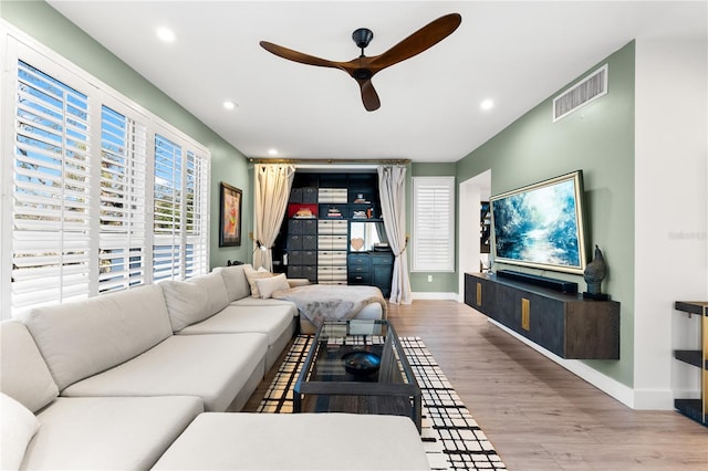 living room featuring light hardwood / wood-style flooring and ceiling fan