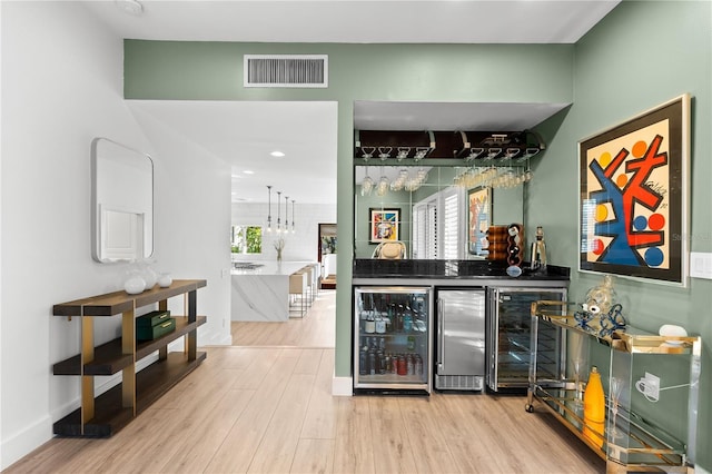 bar featuring wine cooler and light wood-type flooring