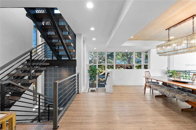 stairway with wood-type flooring and a chandelier