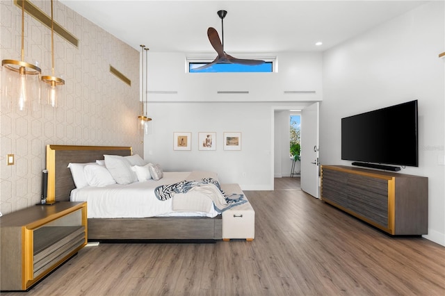 bedroom with a high ceiling and hardwood / wood-style floors