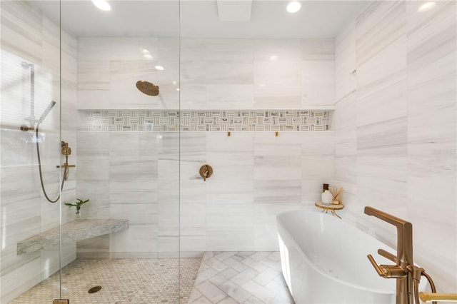 bathroom featuring plus walk in shower and tile walls