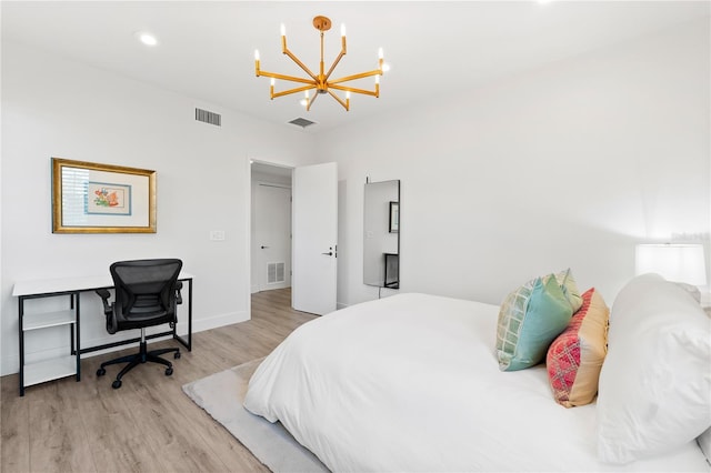 bedroom with light hardwood / wood-style floors and a chandelier