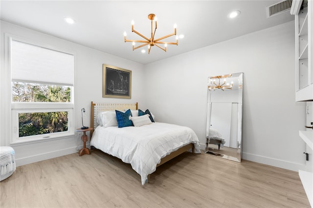 bedroom featuring light hardwood / wood-style floors and a chandelier