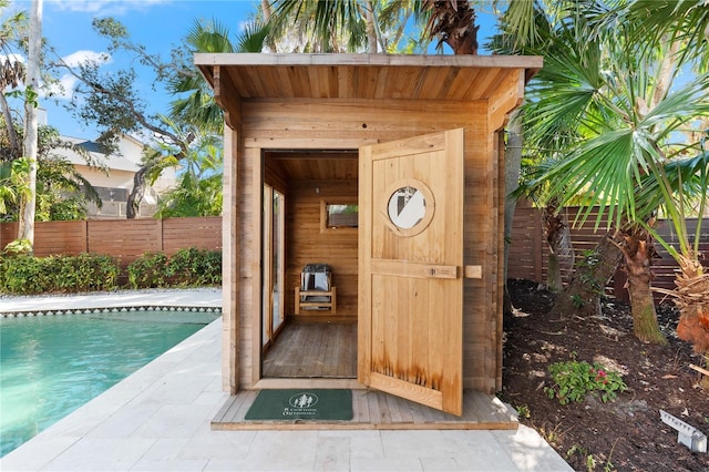 view of outbuilding with a fenced in pool