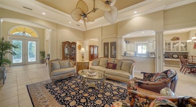 living room with crown molding, a healthy amount of sunlight, and ornate columns