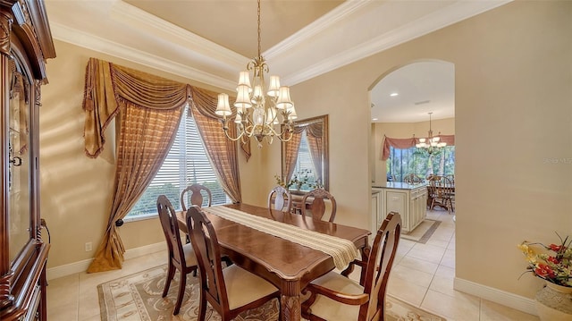 dining space with light tile patterned flooring, a notable chandelier, crown molding, and a tray ceiling