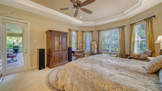 bedroom with crown molding, ceiling fan, a tray ceiling, light carpet, and access to outside