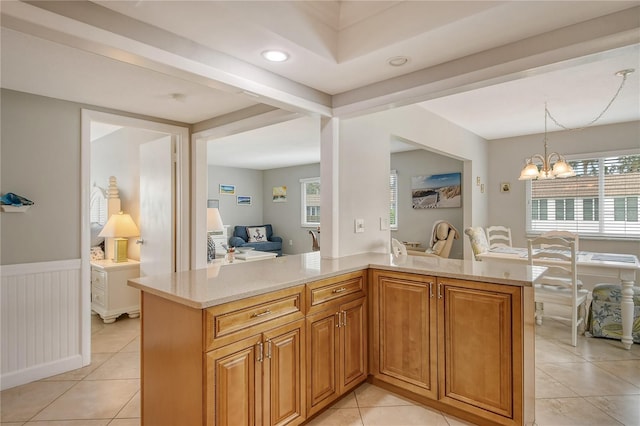 kitchen featuring hanging light fixtures, light tile patterned floors, a notable chandelier, and kitchen peninsula