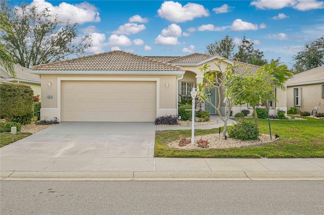 mediterranean / spanish-style house featuring a garage and a front yard