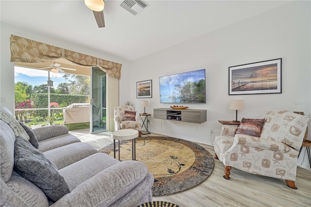 living room featuring wood-type flooring and ceiling fan