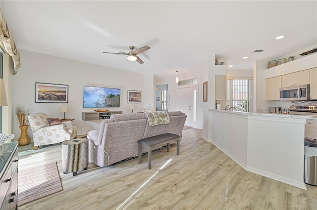 living room featuring ceiling fan and light wood-type flooring