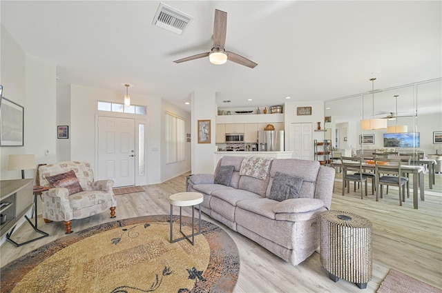 living room with ceiling fan and light hardwood / wood-style flooring