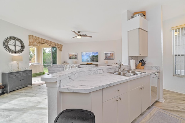 kitchen with sink, light hardwood / wood-style flooring, dishwasher, ceiling fan, and kitchen peninsula