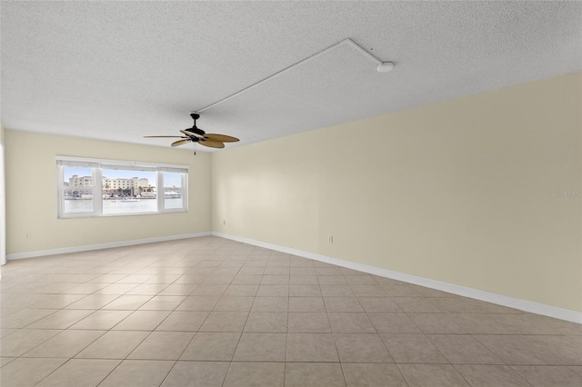 tiled spare room with ceiling fan and a textured ceiling