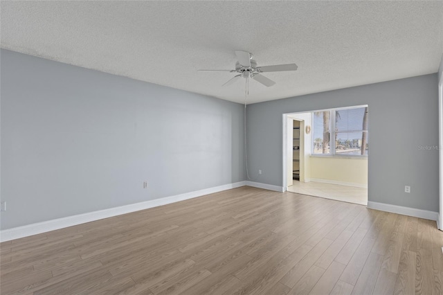 unfurnished room with ceiling fan, a textured ceiling, and light wood-type flooring