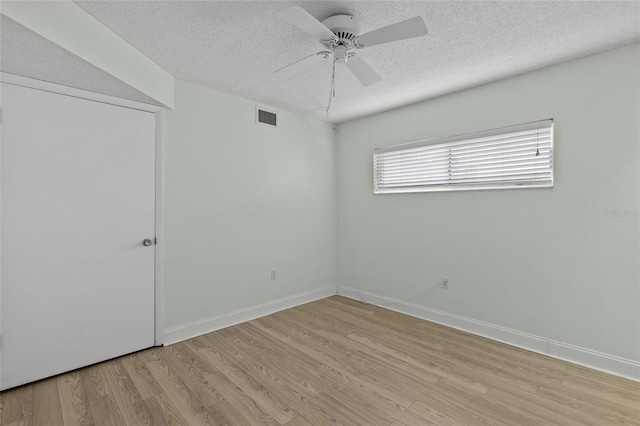 empty room featuring ceiling fan, a textured ceiling, and light wood-type flooring