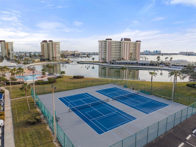 view of sport court featuring a water view and a lawn