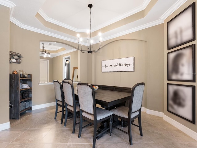 dining room with ornamental molding, light tile patterned flooring, an inviting chandelier, and a tray ceiling