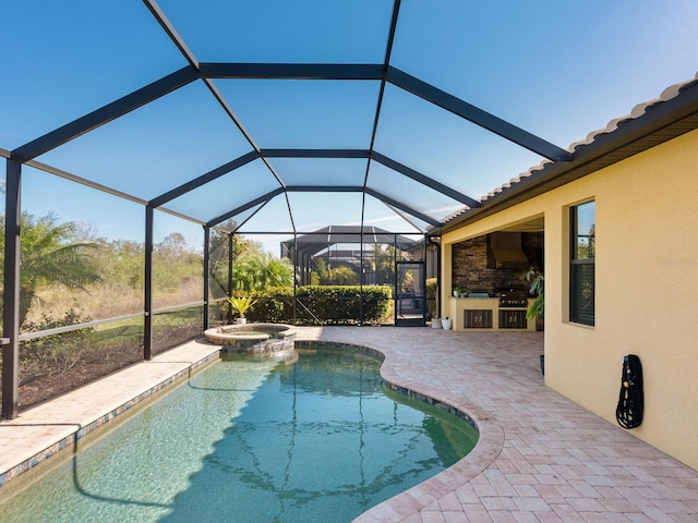 view of pool with exterior kitchen, an in ground hot tub, a lanai, and a patio